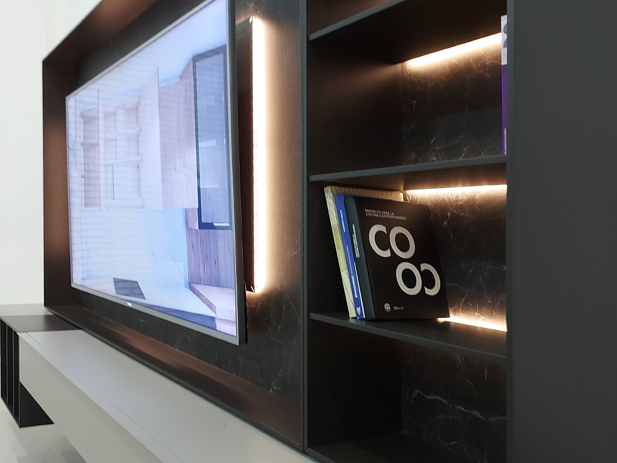 Detalle de mueble de salón moderno para TV con TV encendida y estanterías con leds y libros