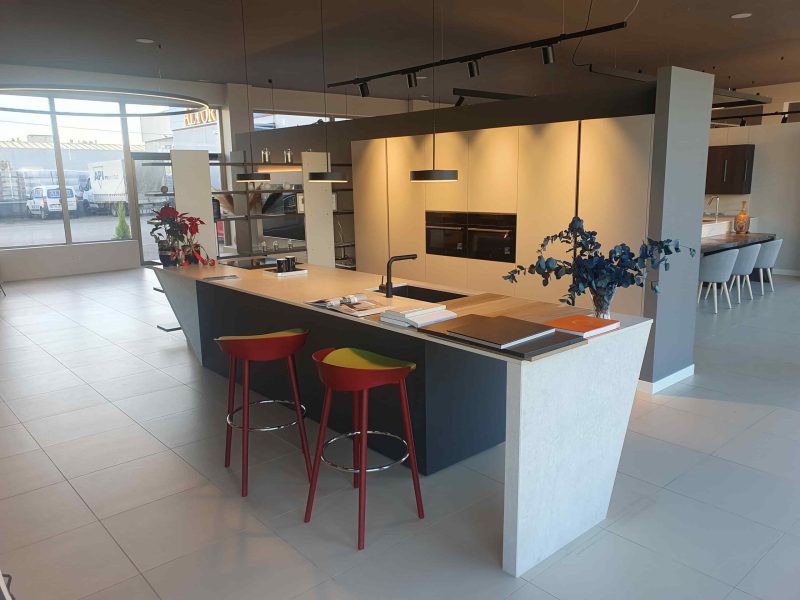 Exposición en tienda de salón y cocinas con muebles e isla central con fregadero